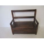 An antique oak hall seat, with cupboard under, length 102.5cm, height 94cm.