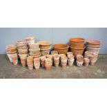 A large quantity of various sized terracotta garden pots.