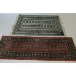An Eastern style red ground rug/runner 190cm x 65cm plus another rug 157cm x 100cm.