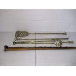 A set of brass fire irons along with a silver topped cane and one other