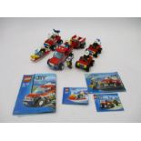 A collection of completed Lego City fire vehicles with instruction leaflets including Off Road