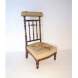 A mahogany framed Prie Dieu chair, with tapestried upholstery and turned supports.