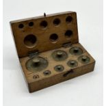 A antique set of cased brass weights marked "DR"