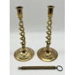 A pair of barley twist brass candlesticks along with a set of broad arrow stamped Salter scale