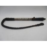 An African camel whip with plaited leather handle, decorated with mother of pearl and ebony