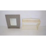 A painted wall hanging dish rack along with a wall hanging mirror.
