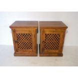 A pair of hardwood bedside cabinets.