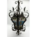 A turn of the century wrought iron lamp with stained glass panels. One panel is loose but present.