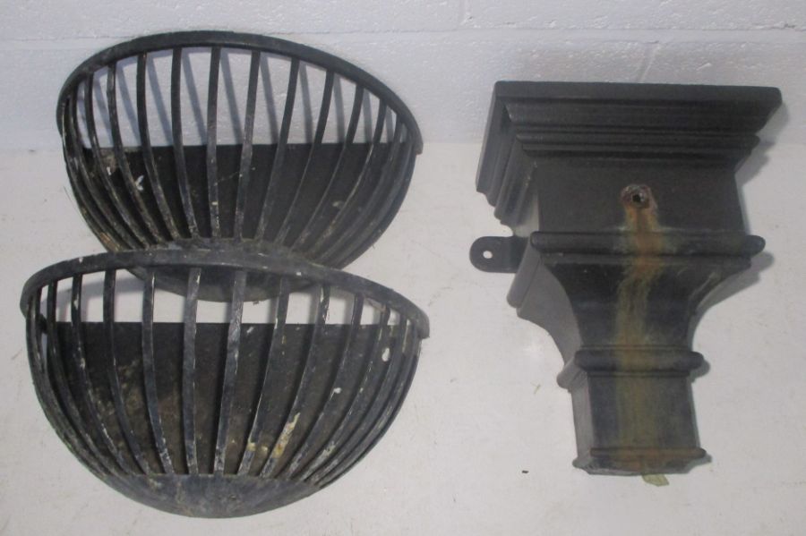 A cast iron hopper along with two wrought iron wall planters.