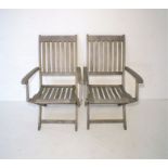 A pair of wooden folding garden chairs.