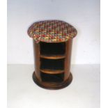 A circular stool with padded seat and two shelves below