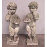 Two weathered reconstituted stone cherubs. Approx height 68cm