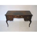 An Edwardian mahogany serpentine fronted ladies writing desk with three drawers, raised on