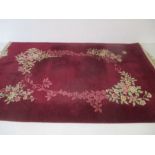 A Chinese red ground rug with floral decoration. 280cm x 180cm