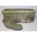 A reconstituted stone garden trough with a lion's head decoration to side along with a stone boot.