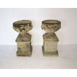 A pair of reconstituted stone garden urns on plinths, height 74cm, diameter 38cm.