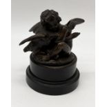 A small bronze figure of a cherub holding a goose on slate base - approx. 15cm high