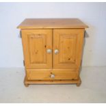 A pine cupboard, with two doors and single drawer below, length 68cm, height 73cm.