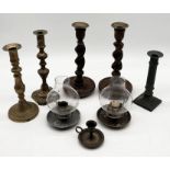 A collection of wooden and brass candlesticks along with two antique candle holders with shades