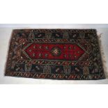 An Eastern red ground rug, with geometric designs, 213cm x 120cm.