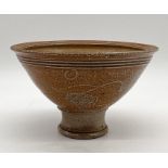 A salt glazed studio pottery bowl with landscape design on raised base with indistinct mark