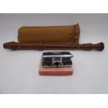 A Kung wooden recorder in case along with a pair of pocket binoculars