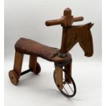 A vintage wooden ride on push-along horse with leather seat