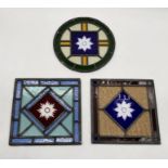 Three vintage stained glass panels with leaded light detailing and central flower motif