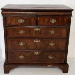A Queen Anne chest of five drawers on bracket feet with cushion fronted "secret" drawer