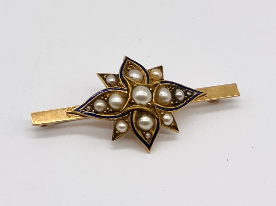 A 15ct gold flower shaped brooch with enamel detailing and set with seed pearls, total weight 7g