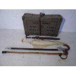 A vintage laundry box along with a shooting stick, walking stick etc.