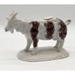 A 19th century Staffordshire pottery creamer in the form of a standing goat on oval base