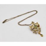 An Art Nouveau 9ct gold pendant set with peridot and seed pearls on an unmarked gold chain set