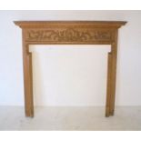 A pine fire surround with decorative moulding, length 140cm, height 130cm.