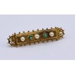 An unmarked Victorian gold brooch set with emeralds and seed pearls, total weight 4.6g