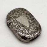A hallmarked silver vesta case with shield shaped cartouche and floral decoration