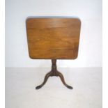 A Victorian elm tip-up table on tripod base with rectangular top.