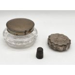 A hallmarked silver topped dressing table pot, silver lidded box and a silver thimble