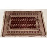An Eastern red ground rug made in Pakistan with repeating pattern 174cm x 122cm
