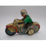 A vintage tin plate motorcycle and rider marked MS-702 (1 plastic clip missing)