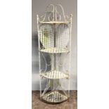 A French style wrought iron folding plant stand with four tiers and scrolling decoration