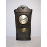 An oak cased wall clock.