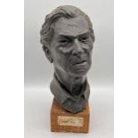 A sculpted bust of a gentlemen on wooden base