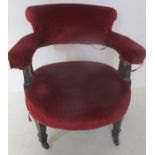 A red velvet tub chair with column detailing.