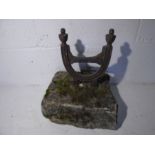 A cast iron boot scraper set into a weathered stone block