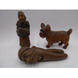 A carved wooden nutcracker along with a carved figure of a dog and a Dutch lady