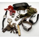 A collection of various whistles, watches, compass and keys etc