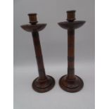 A pair of treen candlesticks with copper banding - height 40cm, drip trays A/F