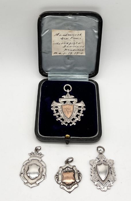 An unmarked silver and gold medallion in fitted case along with three silver medallions