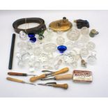A quantity of glassware including bottle stoppers, eye baths, along with a brass inkwell, button